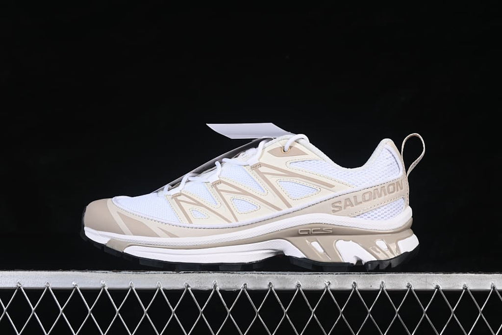 Side profile of a white and tan Salomon XT-6 Expanse sneaker with branded side overlay.