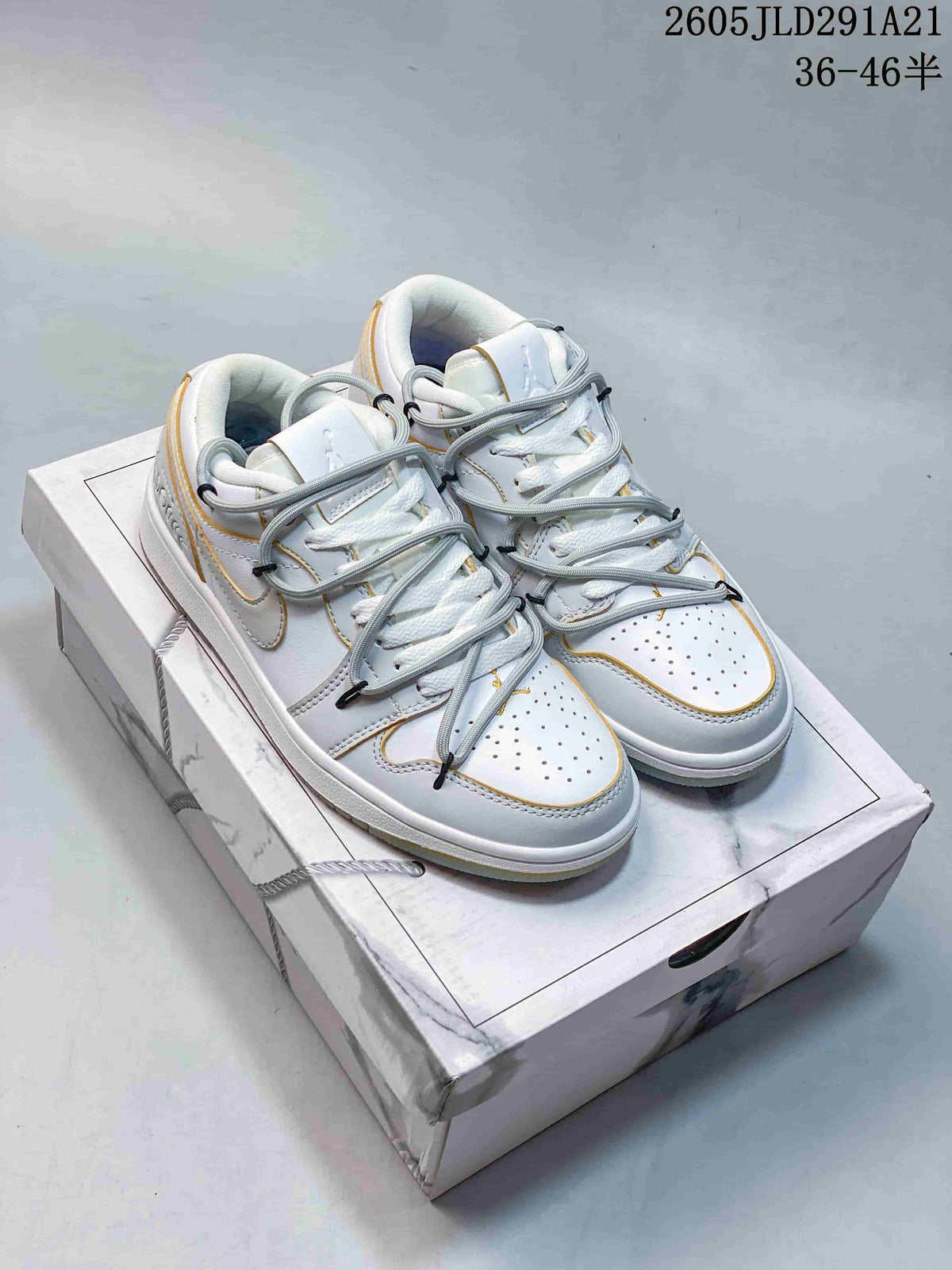 Pair of white and light grey low-top sneakers with gold-colored trim and layered laces