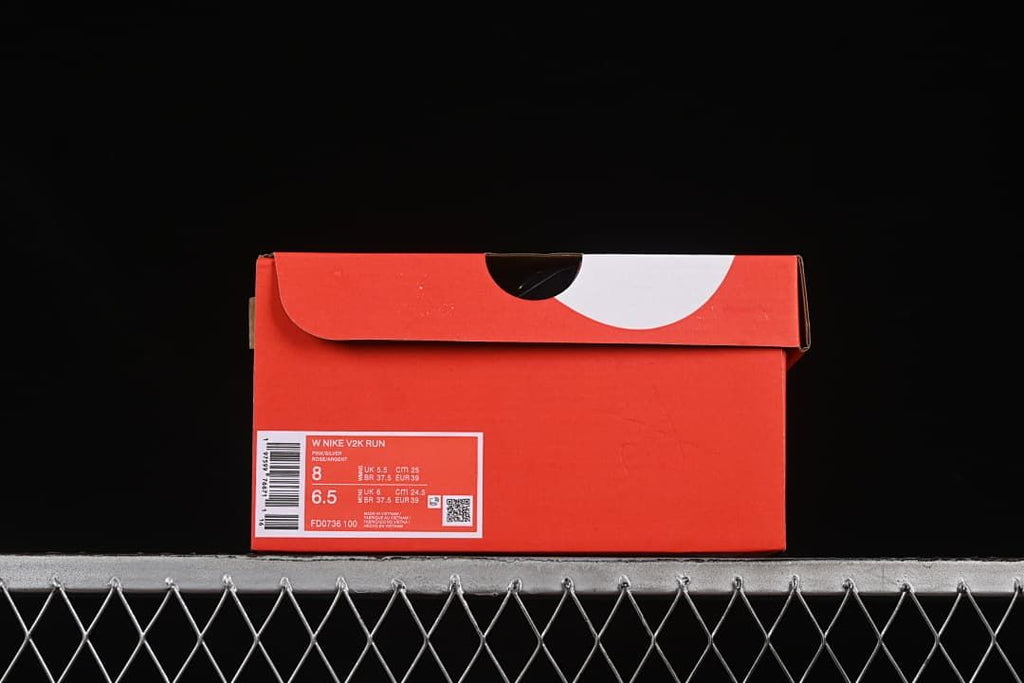 Red shoe box with a label identifying the W Nike V2K Run and style code FD0736-100