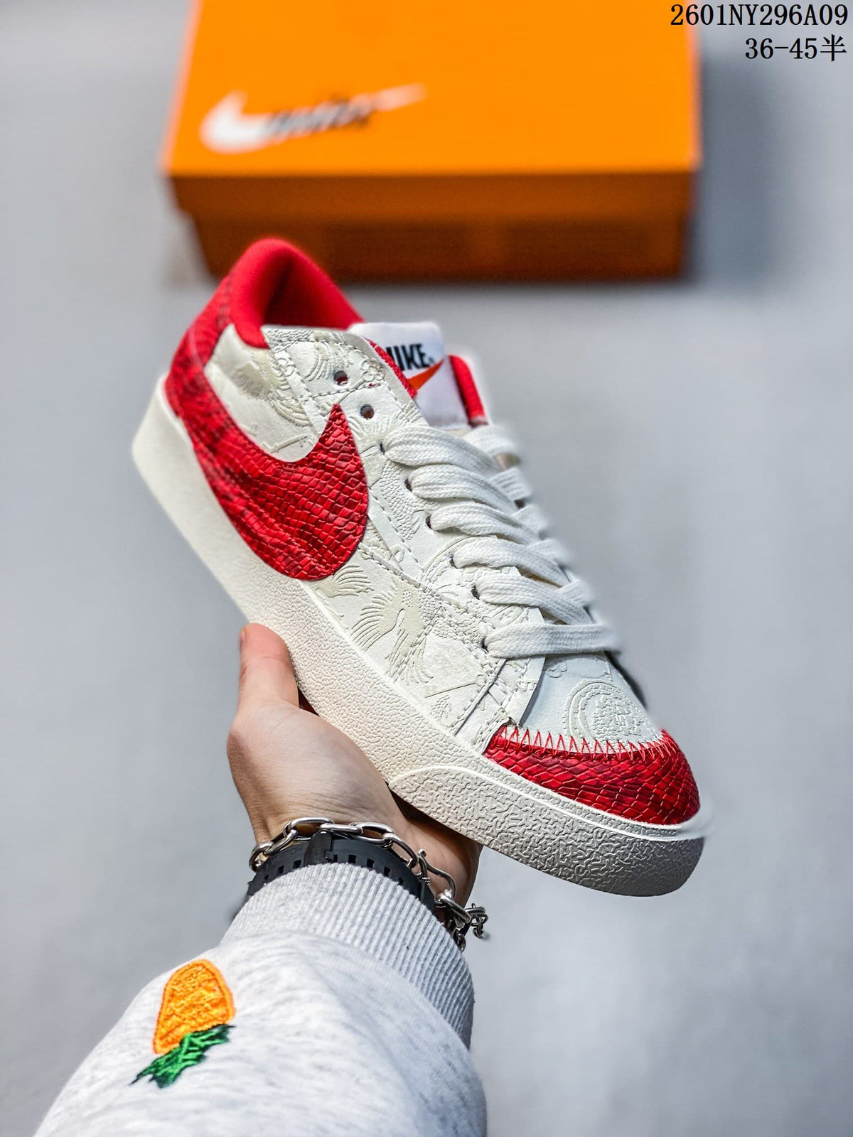 White and red Nike Blazer Low '77 Jumbo sneaker with patterned panels and a textured red Swoosh.