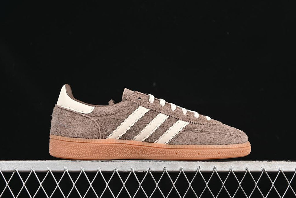 Side profile of a brown sneaker with cream stripes and a gum-colored sole.