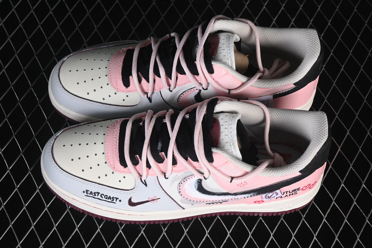 Pair of white and pink low-top sneakers with black accents and decorative graphics