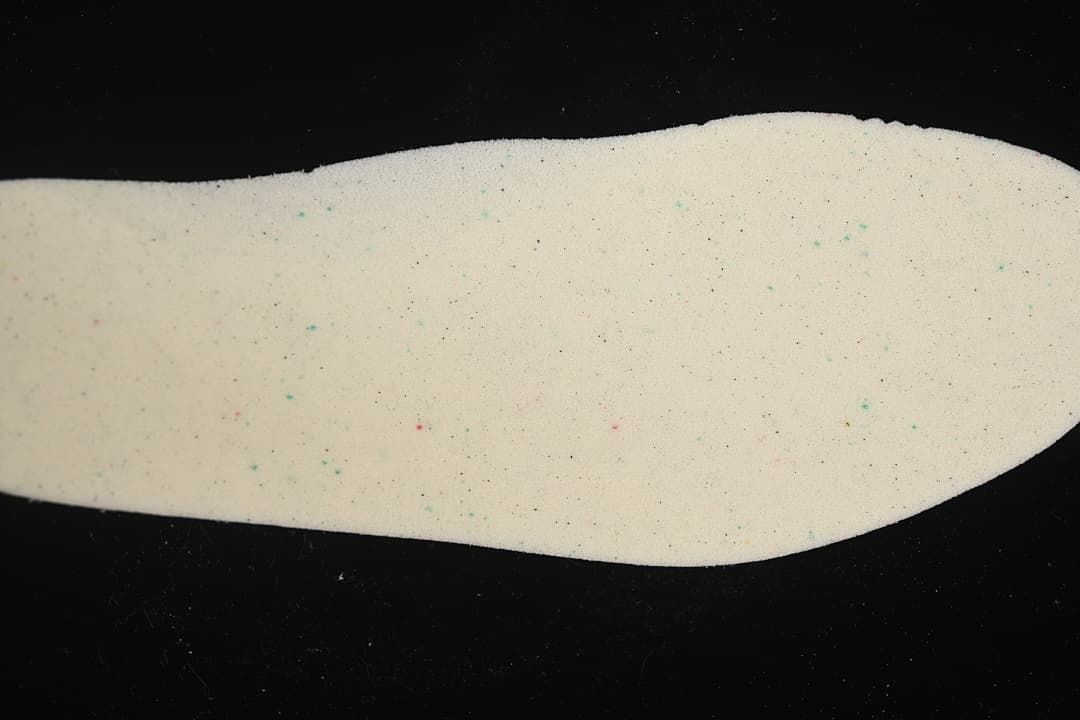 Light-colored shoe insole shown against a dark background