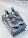 Pair of grey Adidas trail-style sneakers on a shoebox, showing coral accents and lugged outsoles.