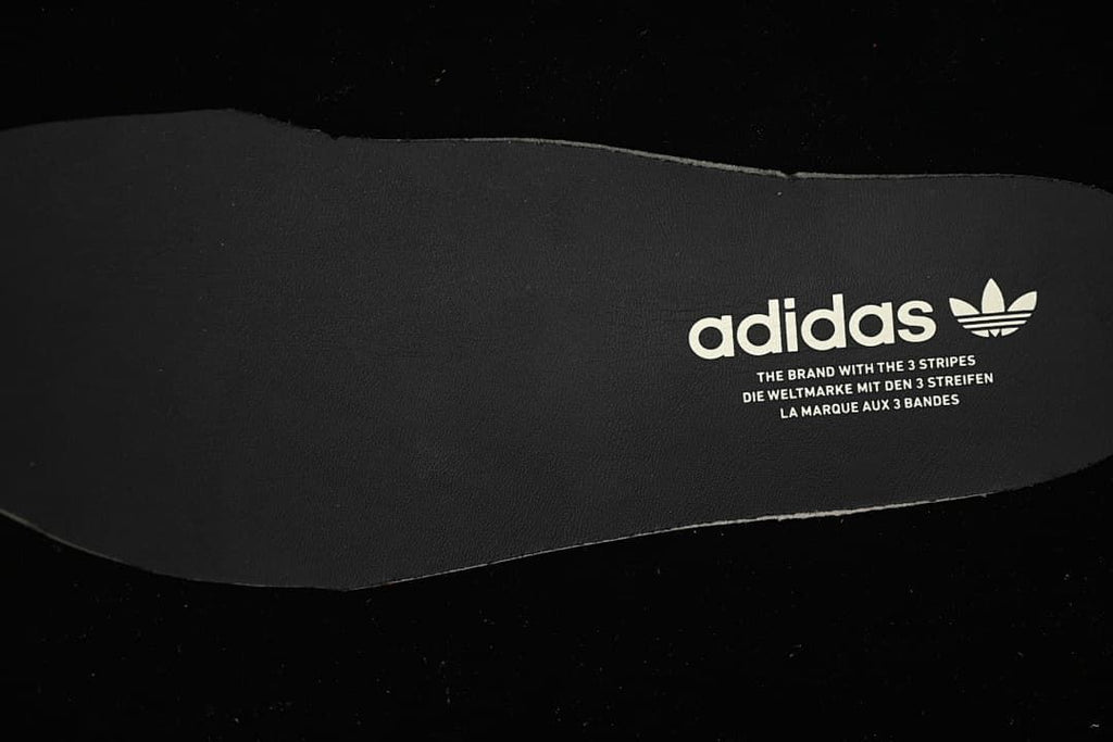 Close-up of a dark insole with adidas branding.