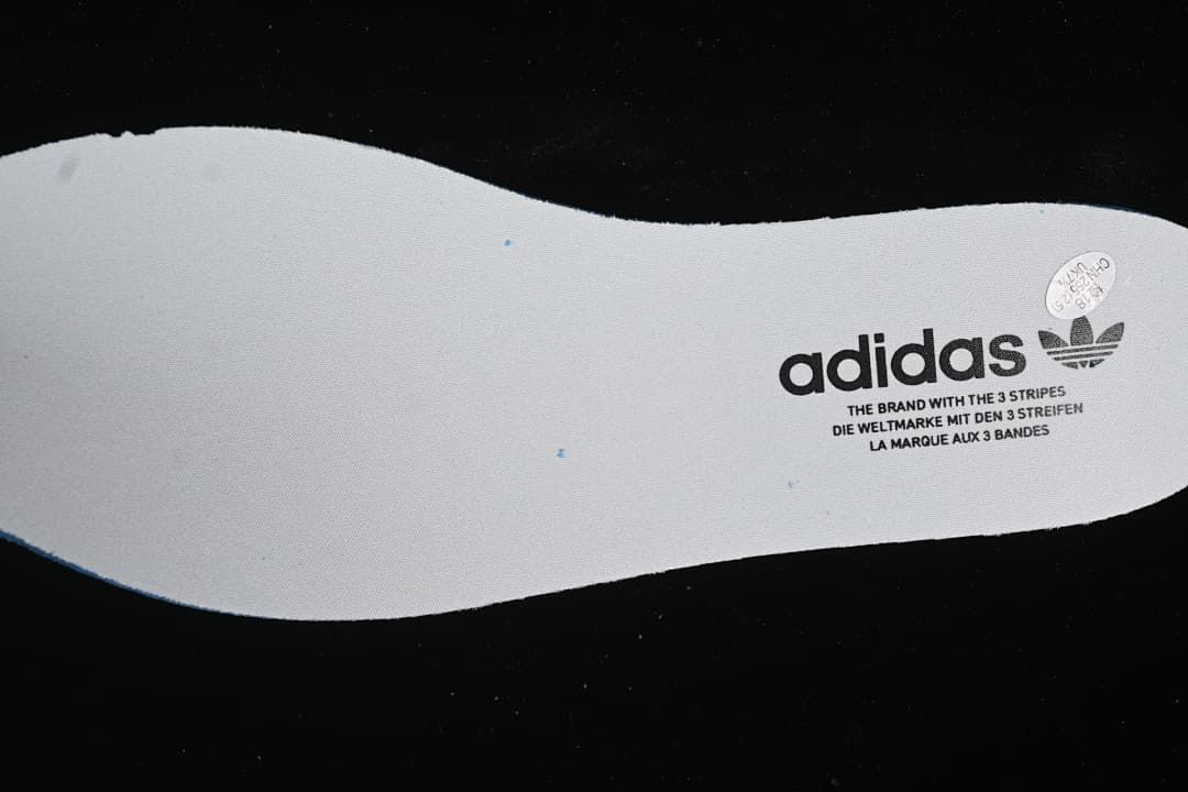 White shoe insert with adidas Trefoil branding.
