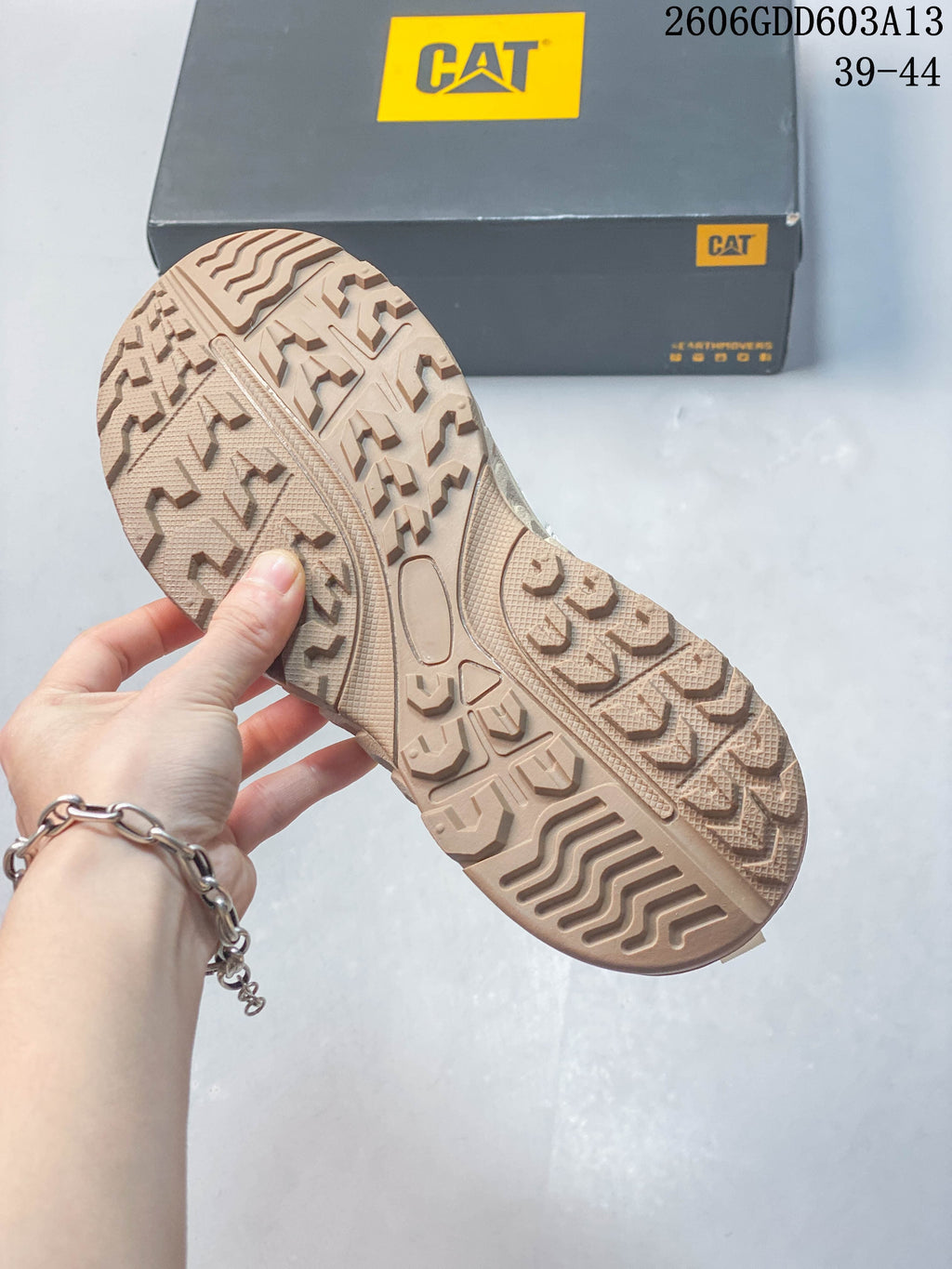 Close-up of the beige patterned outsole on a CAT sneaker