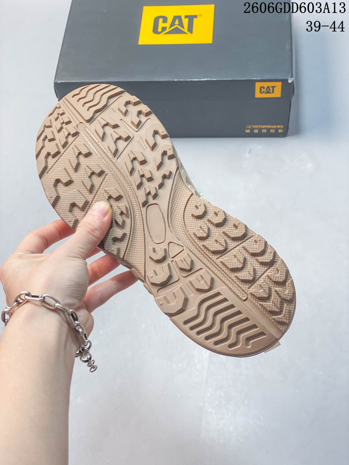 Close-up of the beige patterned outsole on a CAT sneaker