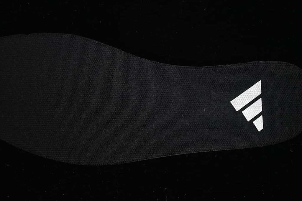 Close-up of a dark insole with a white logo mark