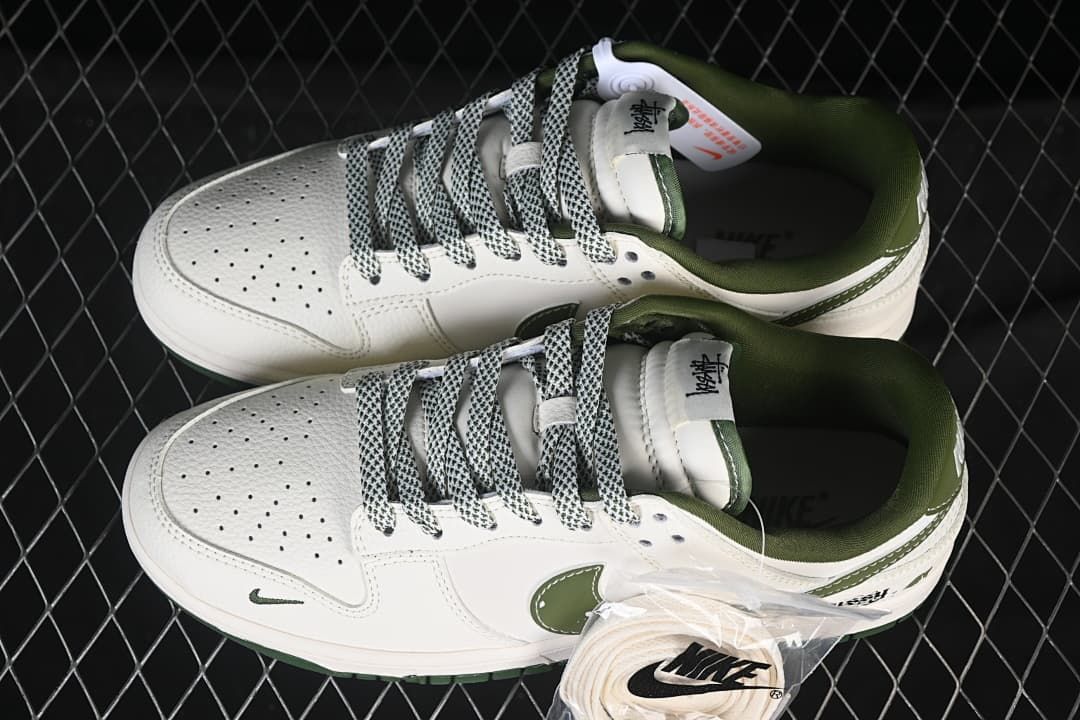 Pair of white and dark green low-top sneakers viewed from above, with patterned laces and an additional white lace set.