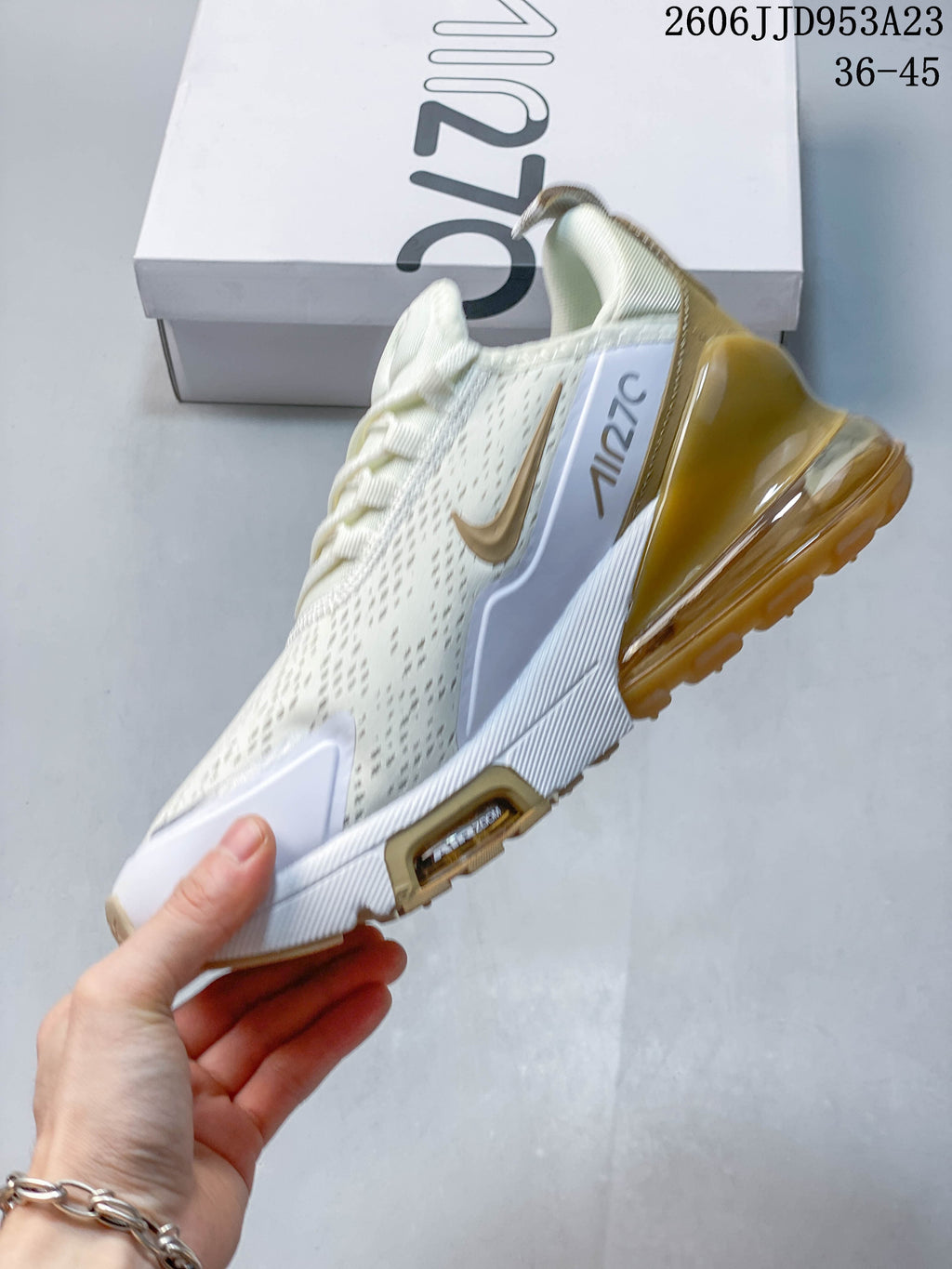 Side view of a white and gold Nike Air Max 270 sneaker