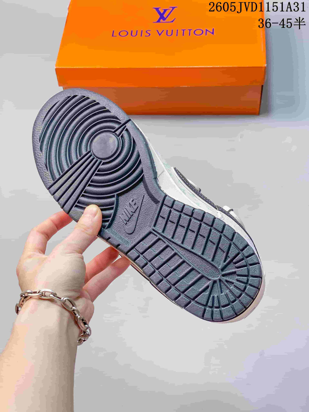 Close-up of the dark patterned outsole of a white and navy low-top sneaker.