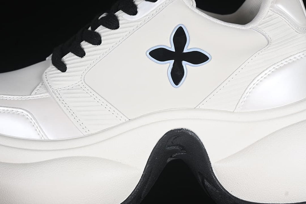 Close-up of the four-petal side emblem, stitched panels, and sculpted sole