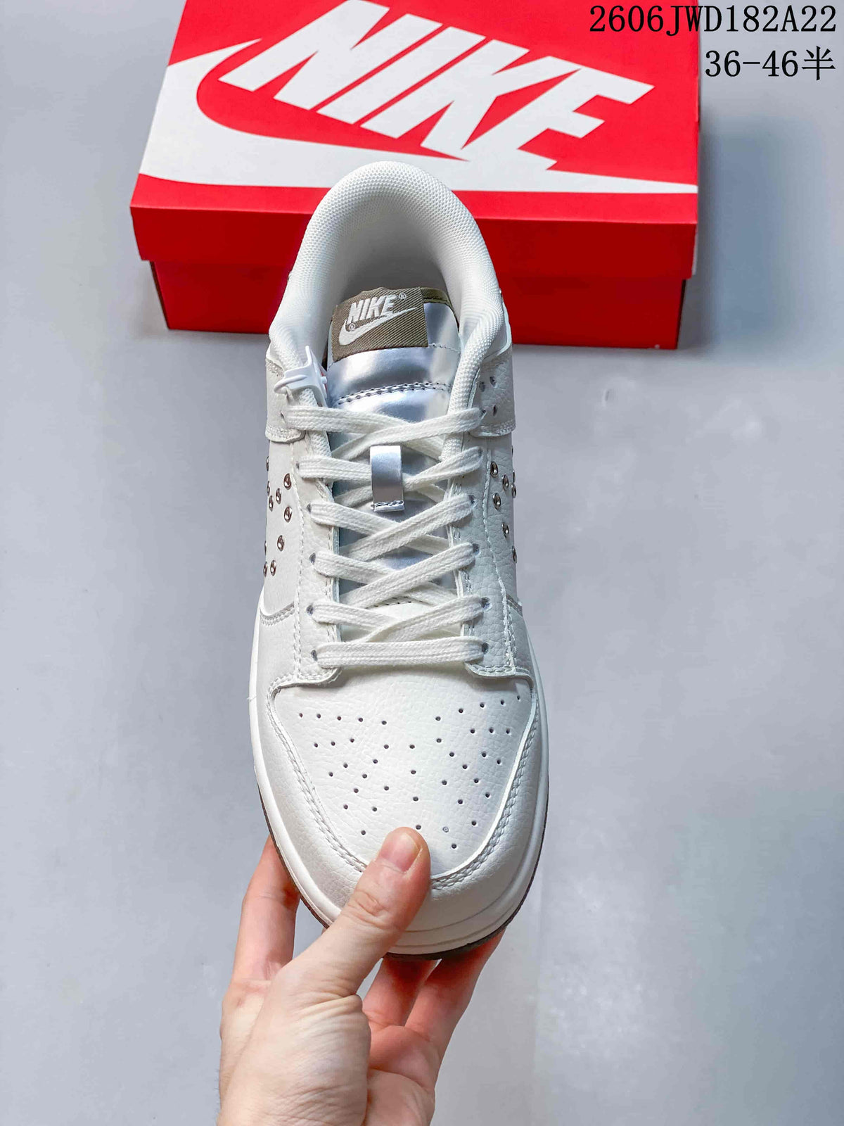 Top view of a white low-top sneaker showing the perforated toe and lace-up front