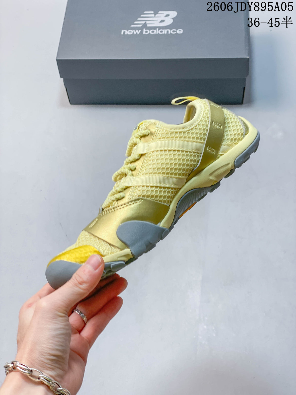Side profile of the yellow low-top sneaker with mesh-like panels and gray outsole accents