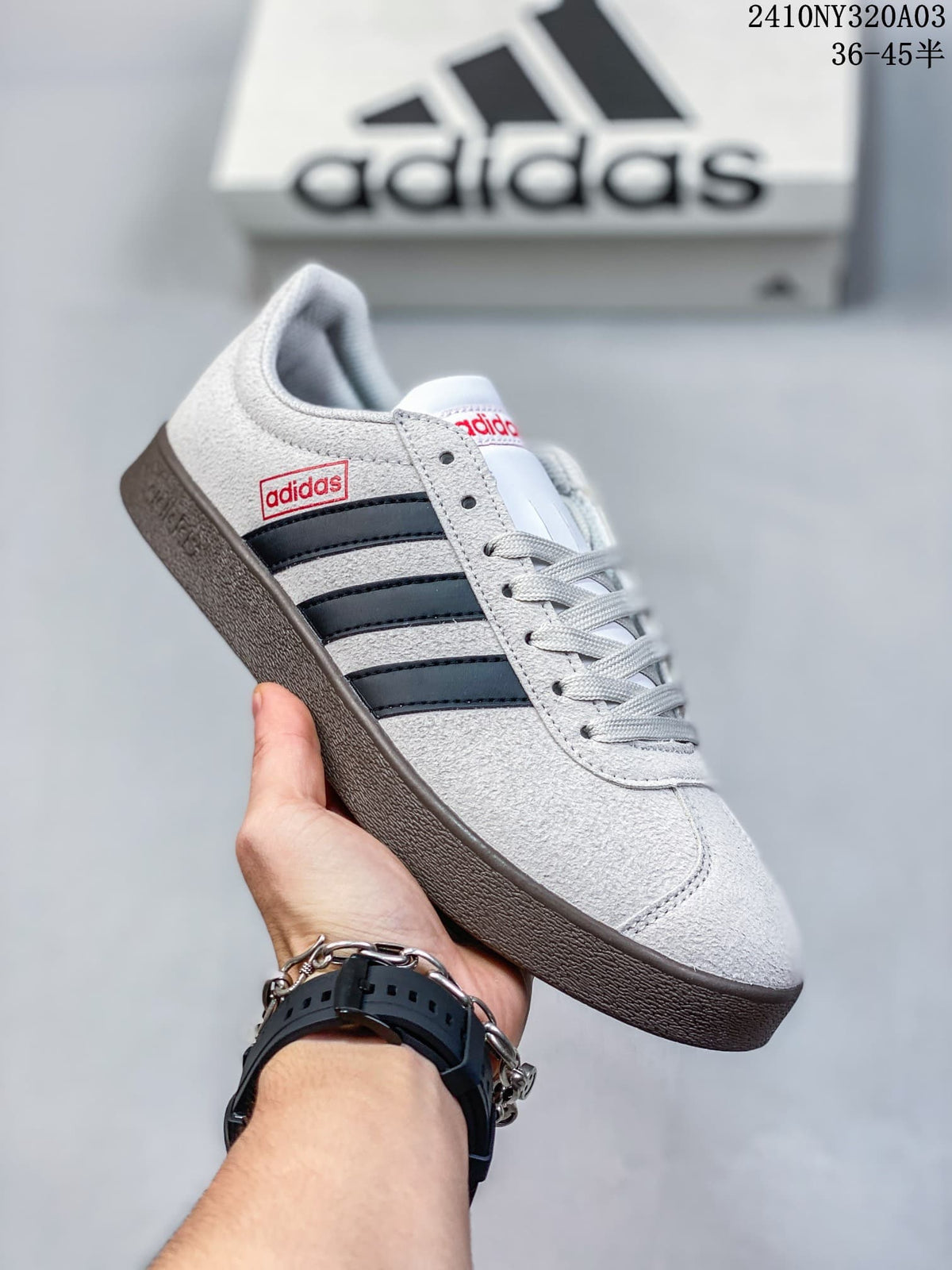 Angled side view showing the light grey upper, dark stripes and lace-up fastening