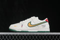 Side view of white Nike SB Dunk Low sneakers with a green-and-gold Swoosh, red heel detail, World Cup-themed side graphic, and green outsole.