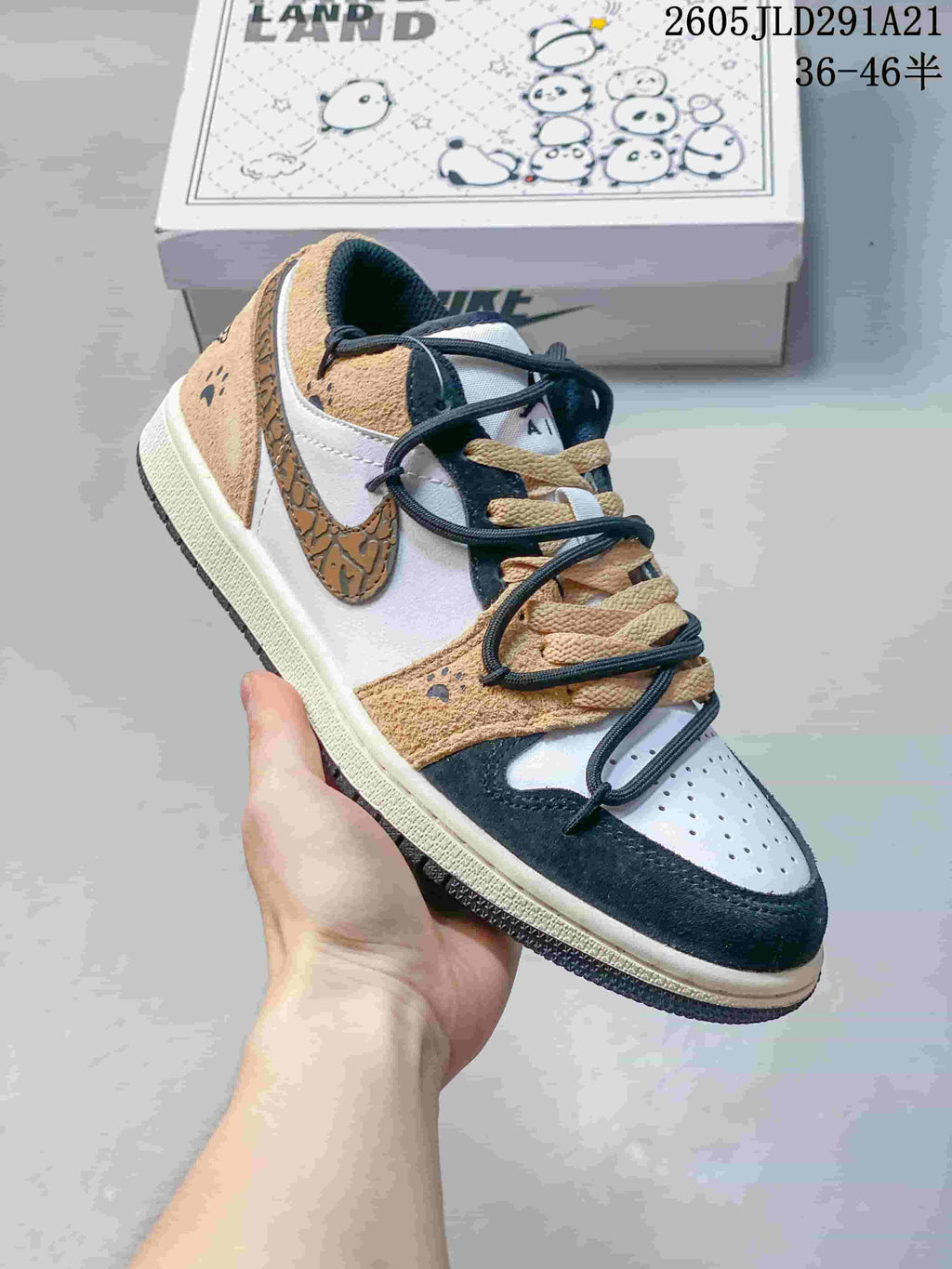Angled side view of a tan, white, and dark navy low-top sneaker