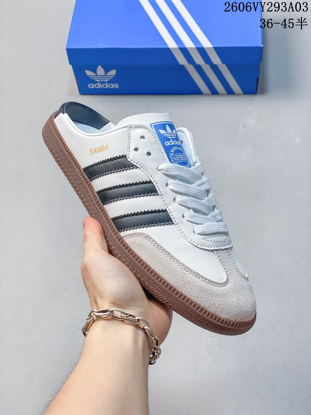 Side view of a white Adidas Samba-branded sneaker with dark stripes and a gum-colored sole.