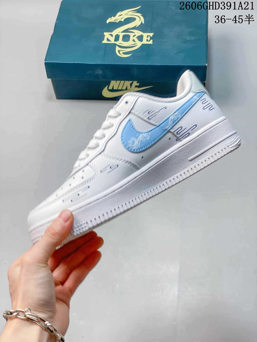 Side view of the white low-top sneaker with a light-blue Swoosh and printed accents.