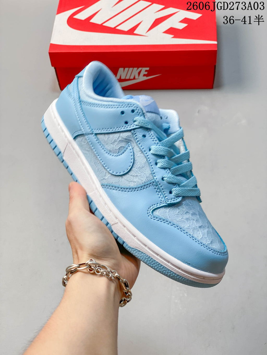 Side view of a blue-and-white low-top Nike Dunk sneaker with patterned panels