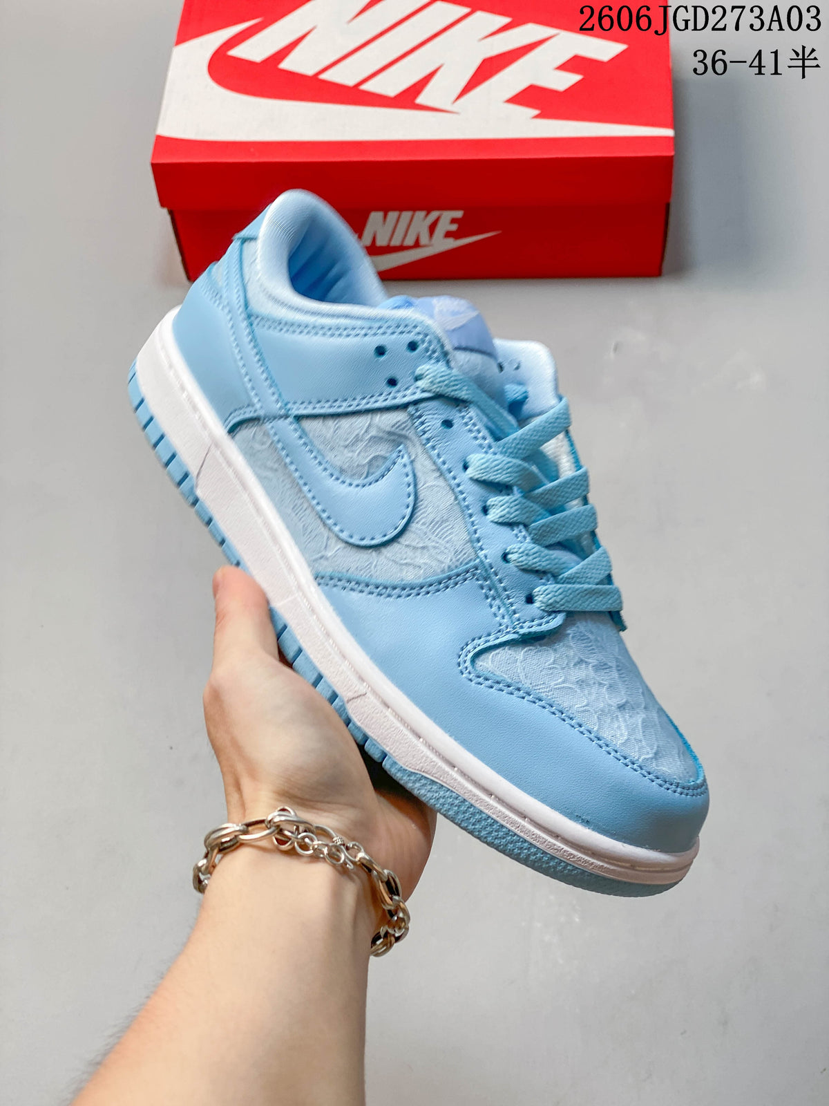 Side view of a blue-and-white low-top Nike Dunk sneaker with patterned panels