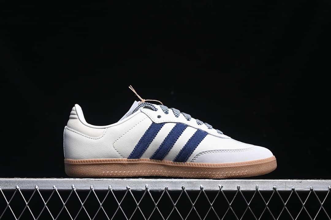 Side profile of the sneaker showing navy stripes and the gum-colored sole.