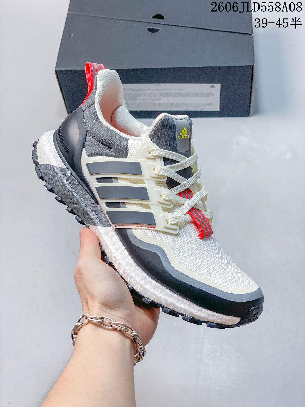 Angled side view of the Adidas sneaker showing the side cage, layered upper and textured sole.