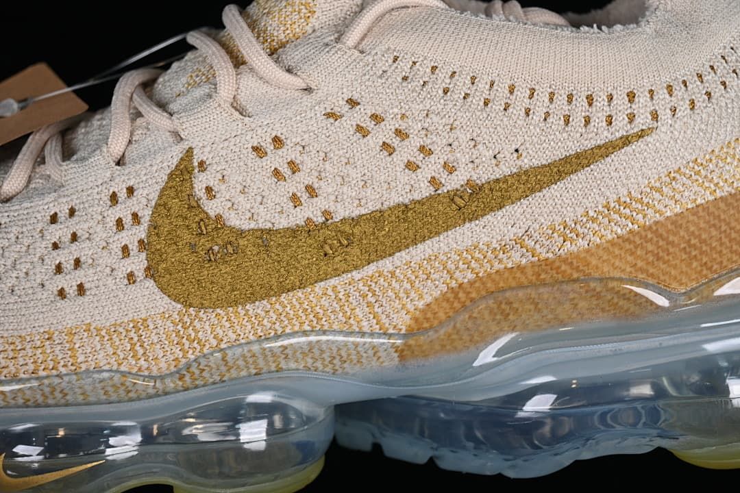 Close-up of the knit side panel, gold-toned Swoosh, and transparent sole.