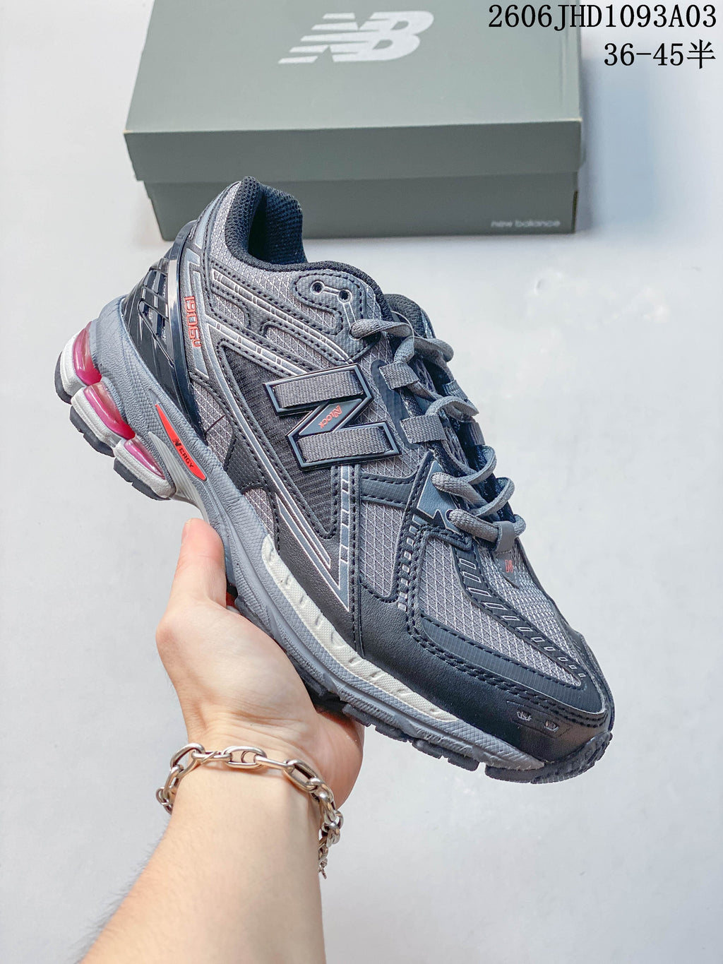 Charcoal gray New Balance 1906U sneaker with bright pink sole accents