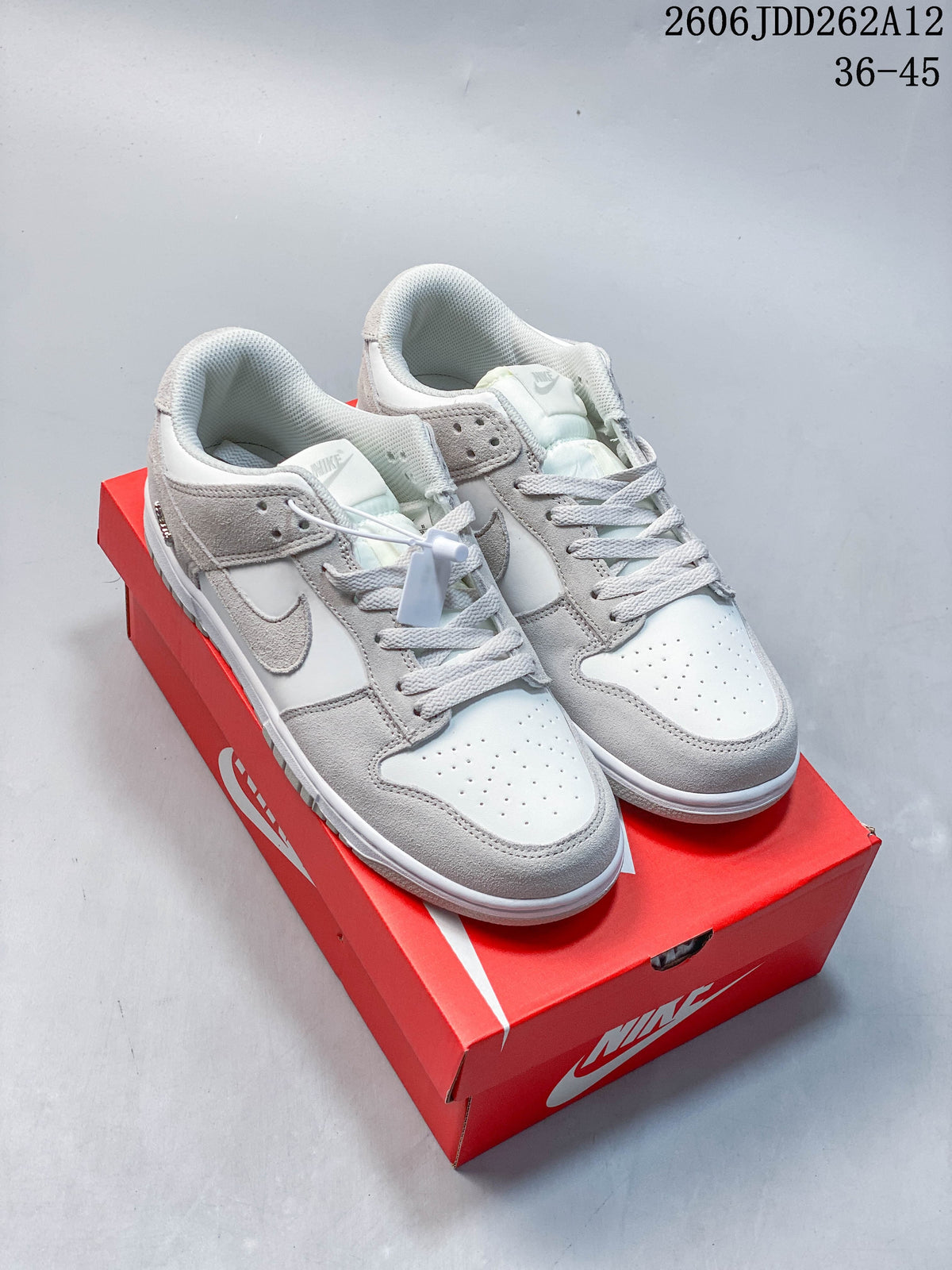 Pair of Sail and grey Nike Mini Swoosh low-top sneakers shown from above at an angle.
