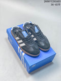 Navy Adidas low-top sneakers with white stripes and gum-colored soles on a blue shoe box.