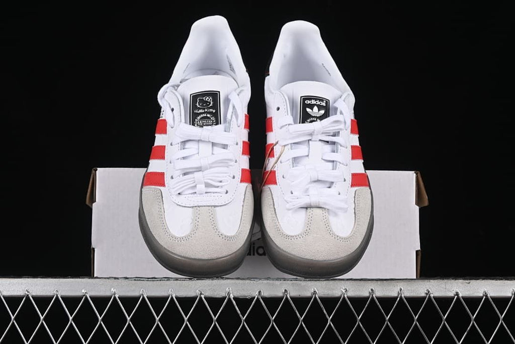 Front view of the pair showing red stripes, white laces, and pale toe overlays.