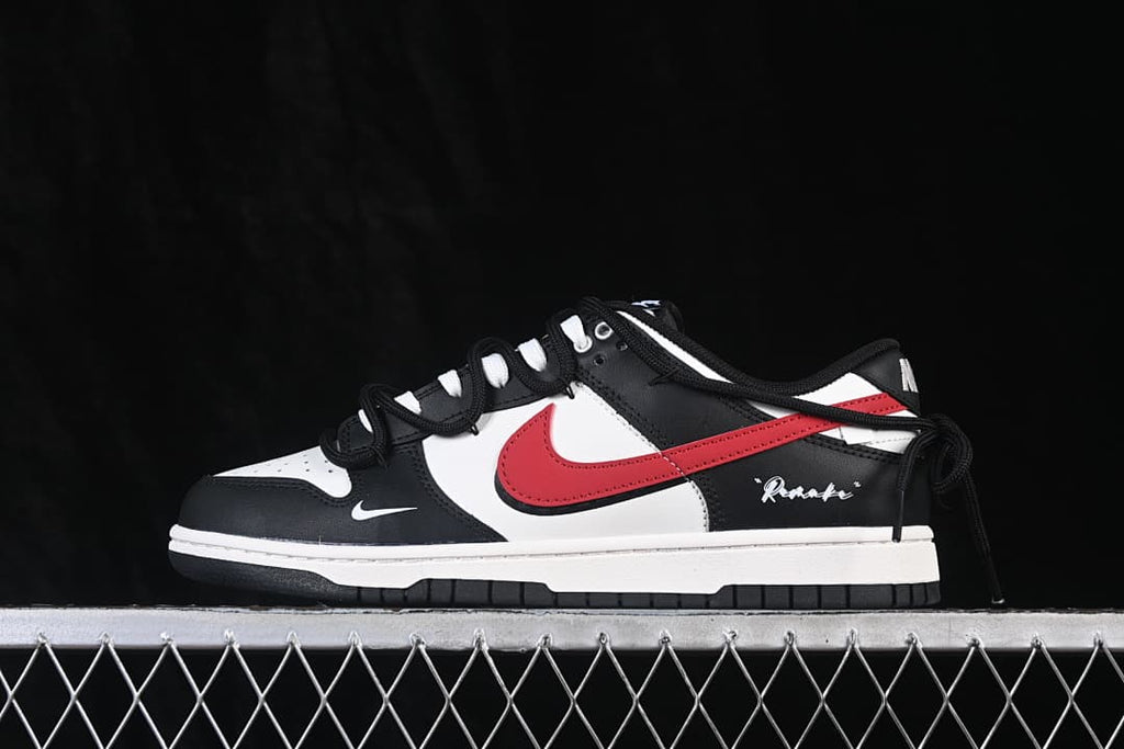 Side view of a black, white, and red Nike SB Dunk Low sneaker with a strap detail.
