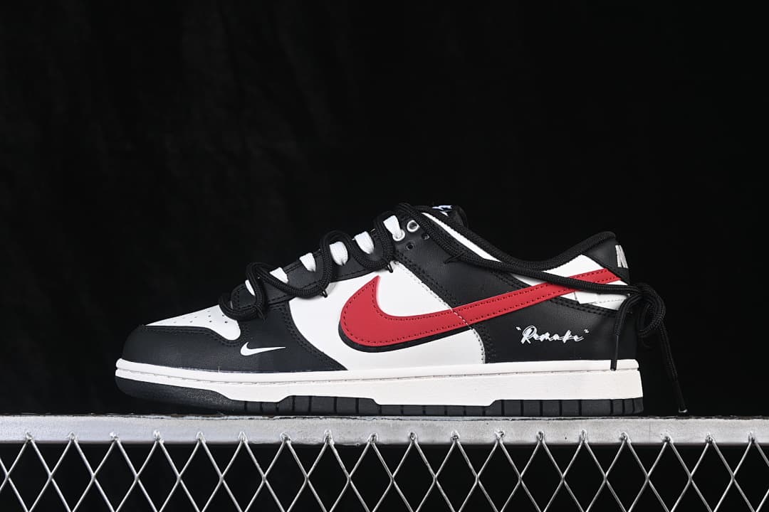 Side view of a black, white, and red Nike SB Dunk Low sneaker with a strap detail.