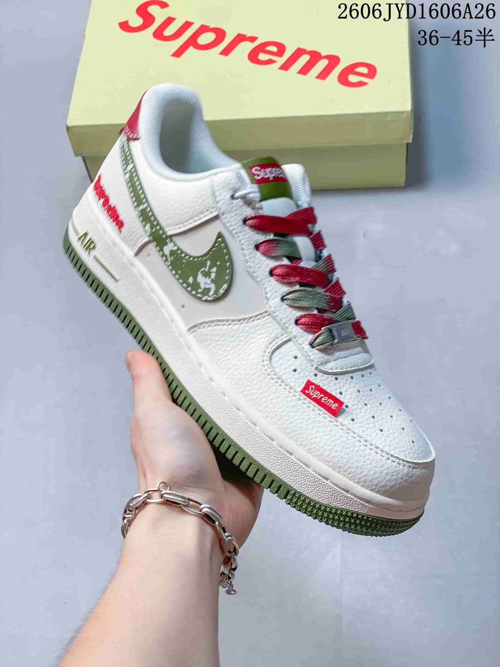 White low-top sneaker with green Swoosh, red details and green outsole