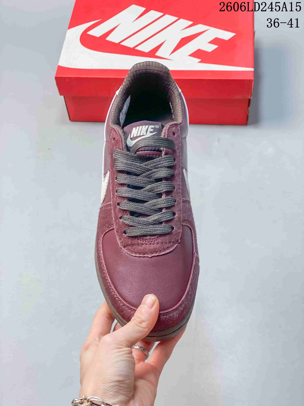 Top view of the sneaker showing its rounded toe, dark laces, and burgundy upper.