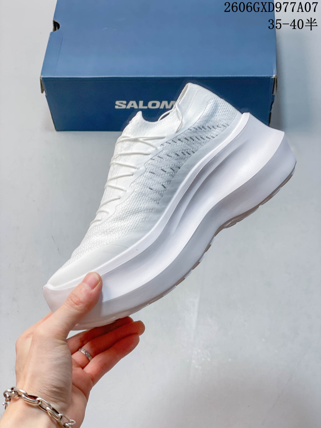 Side profile of a white low-top sneaker showing the upper and thick platform sole.
