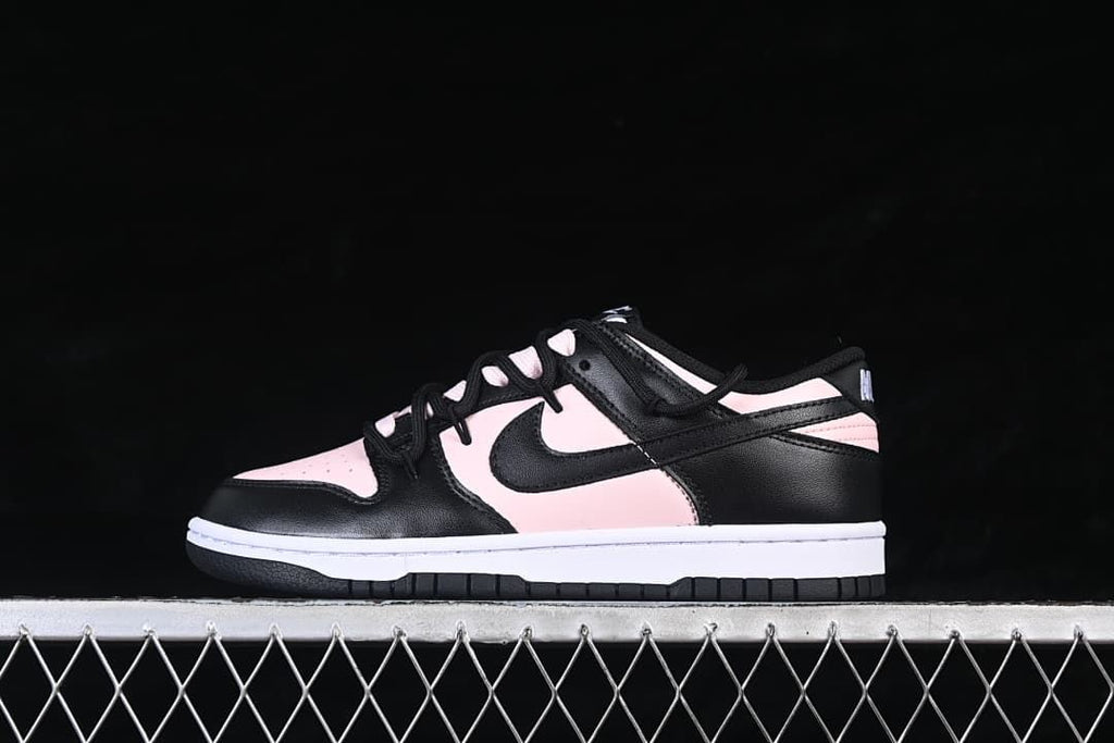 Side view of a black, pale pink, and white low-top sneaker