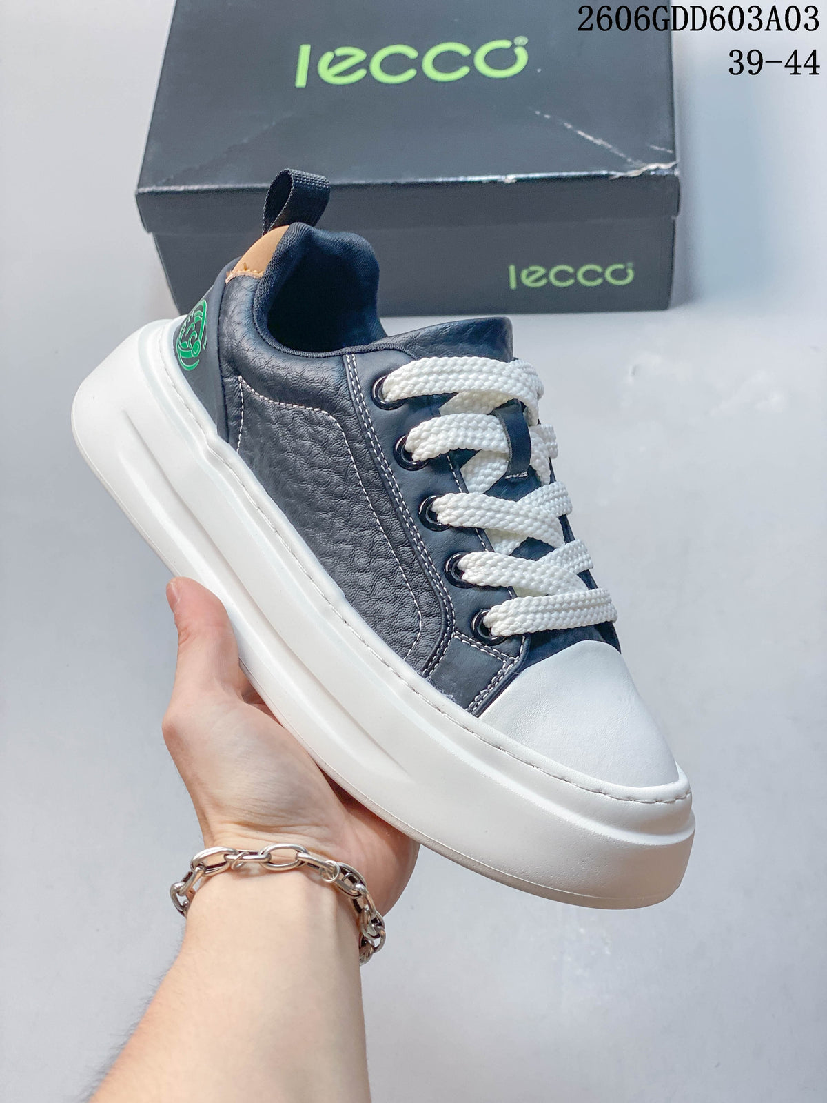Side view of a navy and white low-top lace-up sneaker
