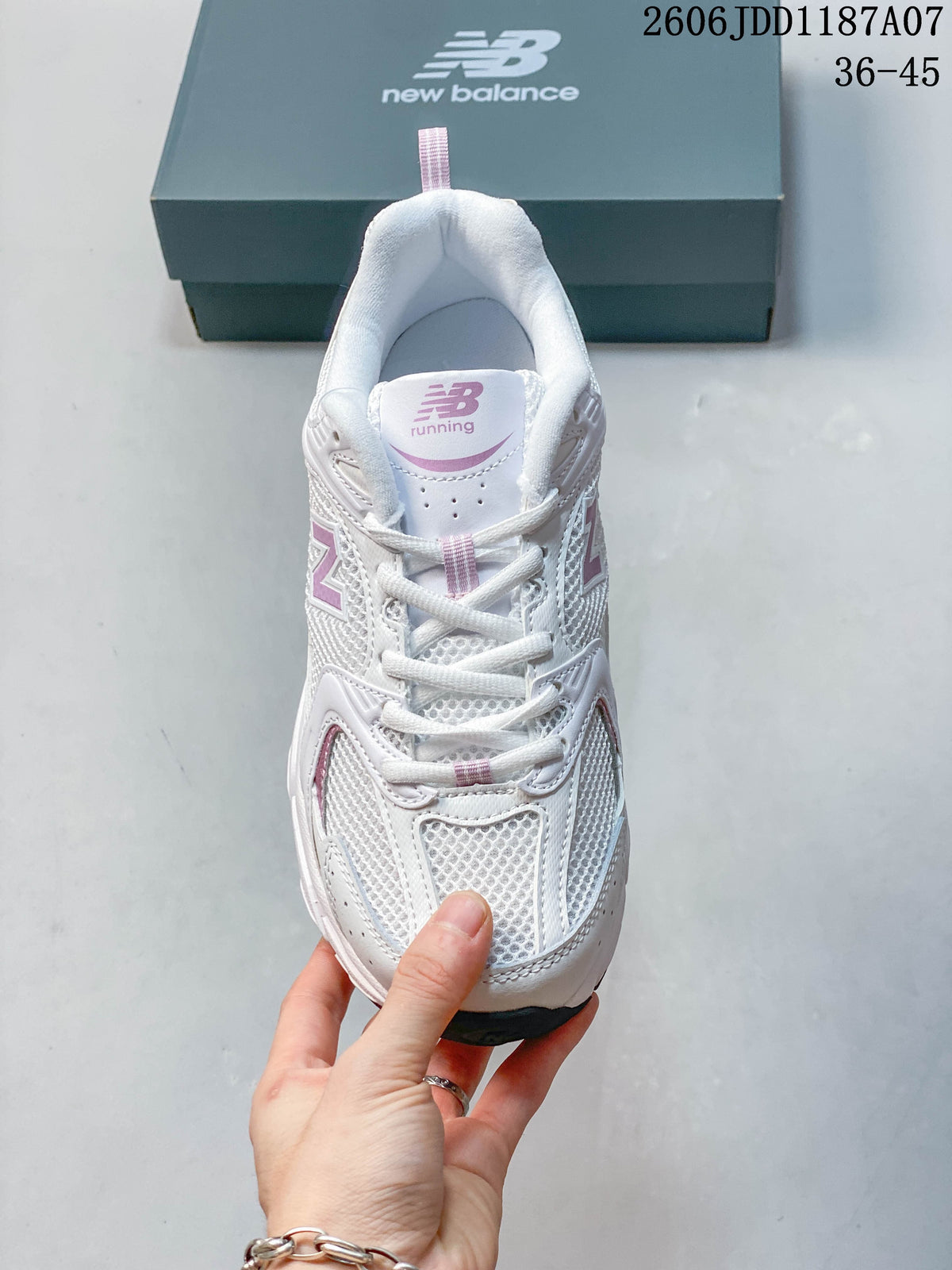 Front view of a white and pink New Balance mesh sneaker