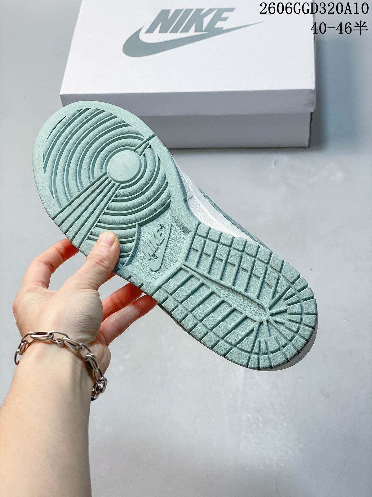 Close-up of the sage-colored outsole tread on a Nike Dunk Low Retro sneaker.