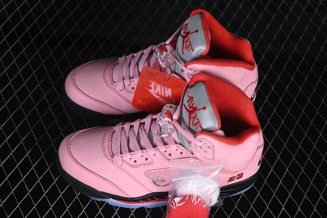 Pair of pink high-top sneakers with red lining and included lace accessories.