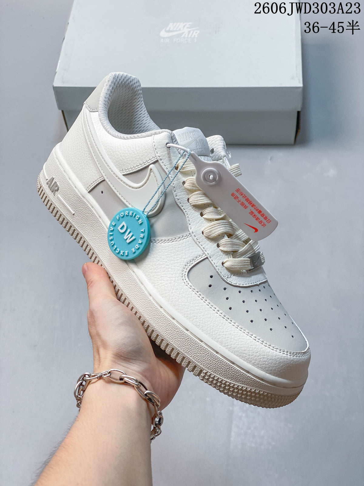 Angled view of a white low-top sneaker with a perforated toe and lace-up front