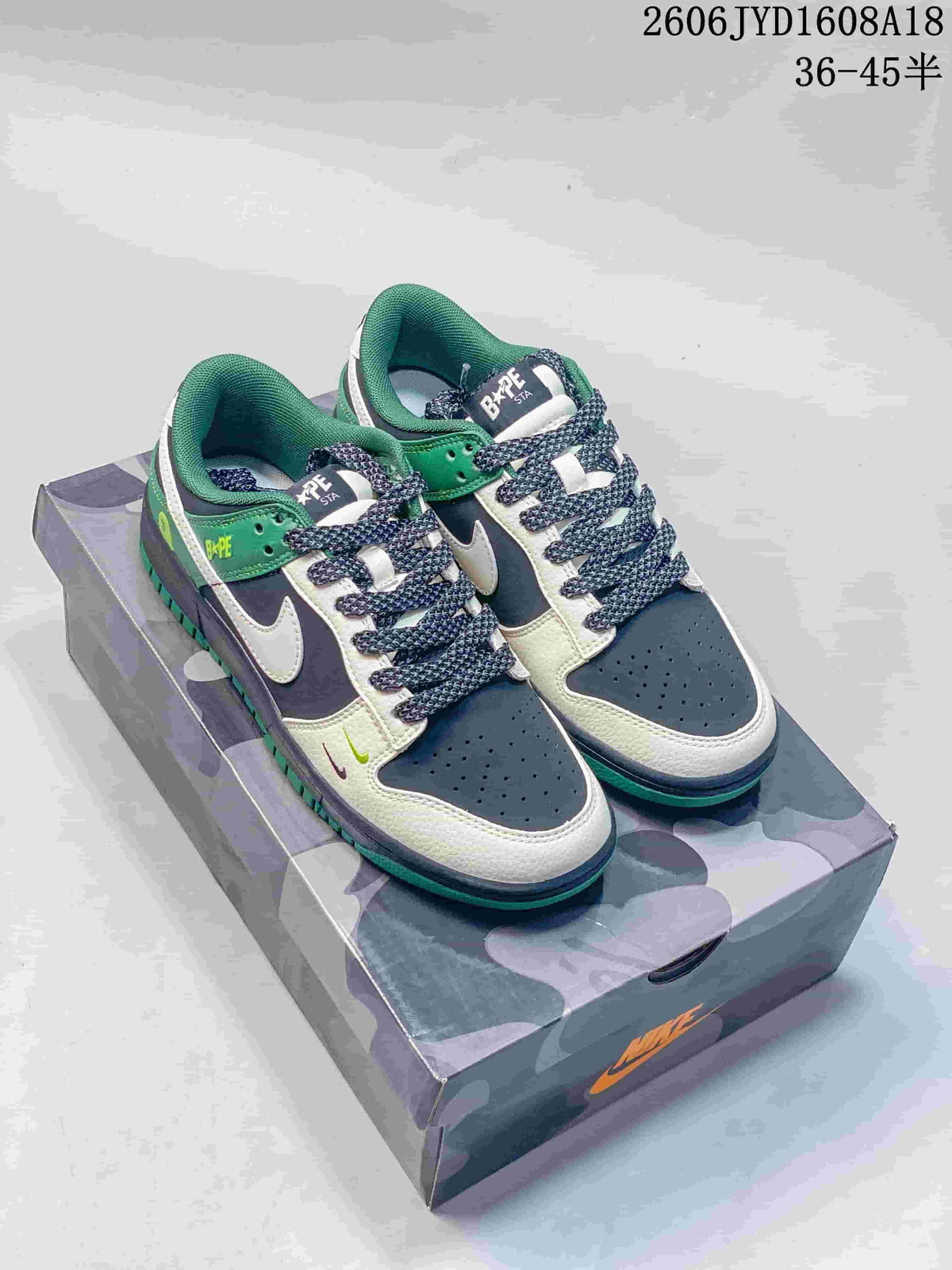 Pair of navy, off-white, and green low-top sneakers displayed on a camouflage-patterned box