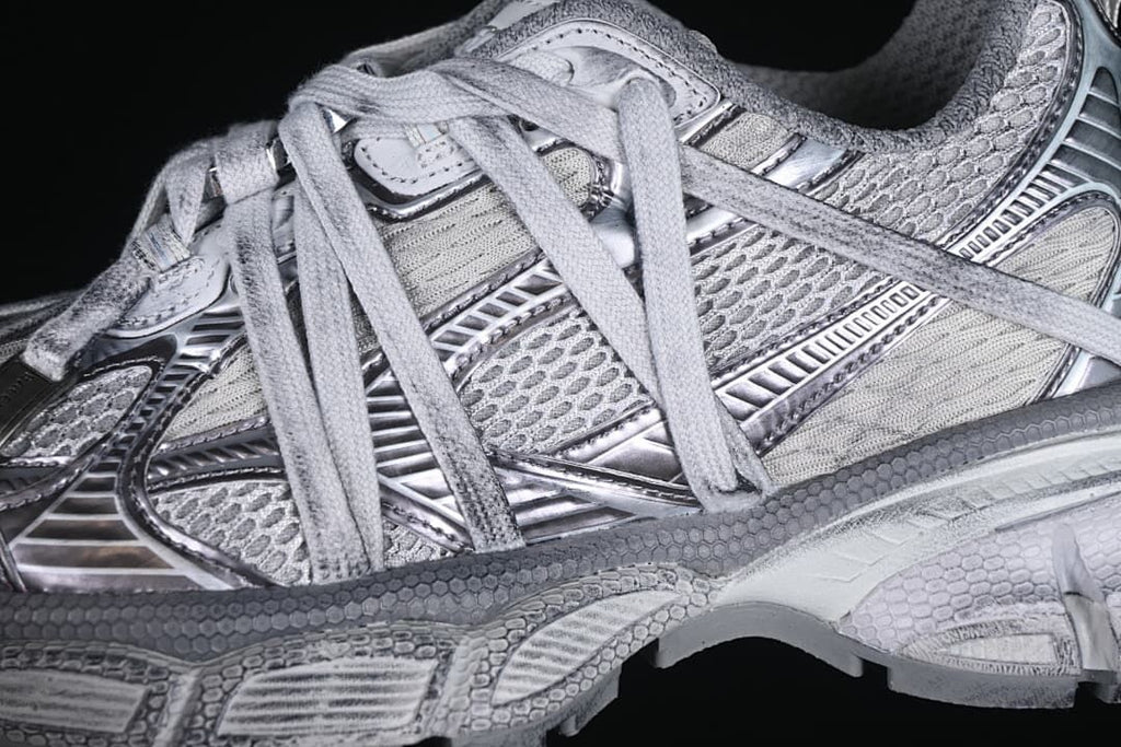 Close-up of layered grey and silver-toned upper panels and laces