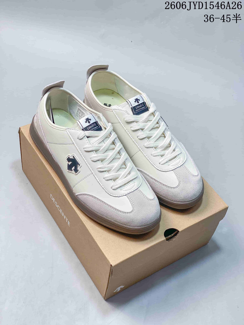 Pair of white and light gray Descente low-top sneakers viewed from above.