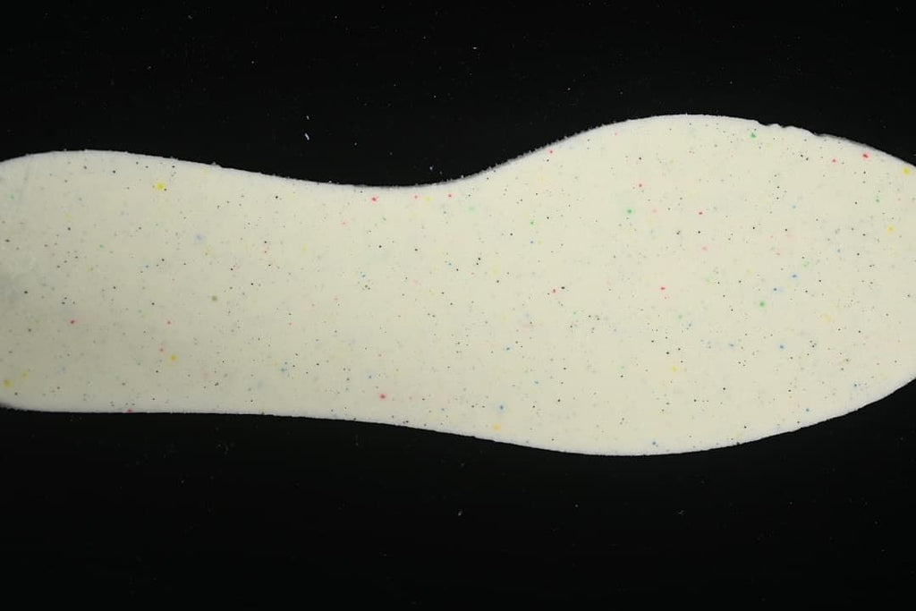 Close-up of a light-colored sneaker insole with small colored flecks