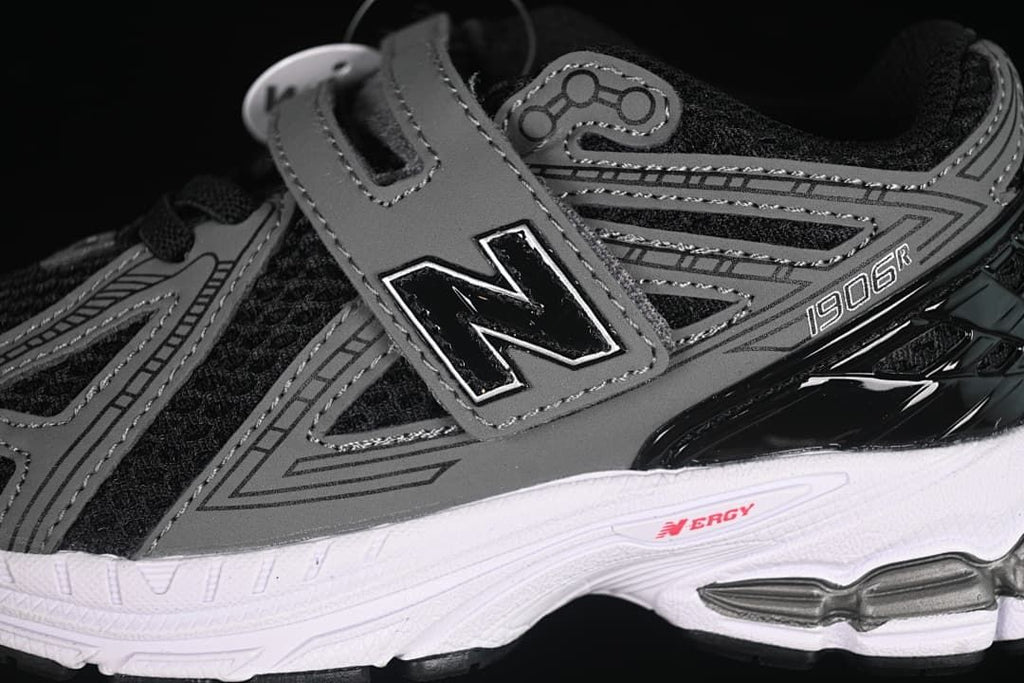 Side detail showing the gray overlays, New Balance logo, hook-and-loop strap, and white midsole.