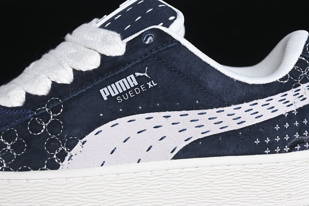 Close-up of the navy upper, light-colored side stripe, stitching, and sole